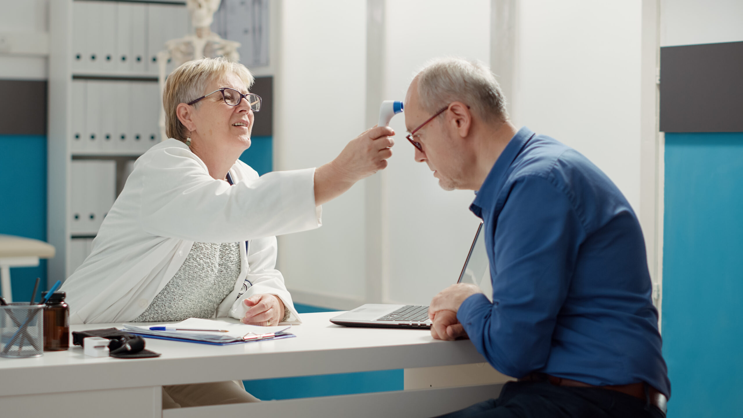 Female Physician Using Thermometer To Measure Temperature